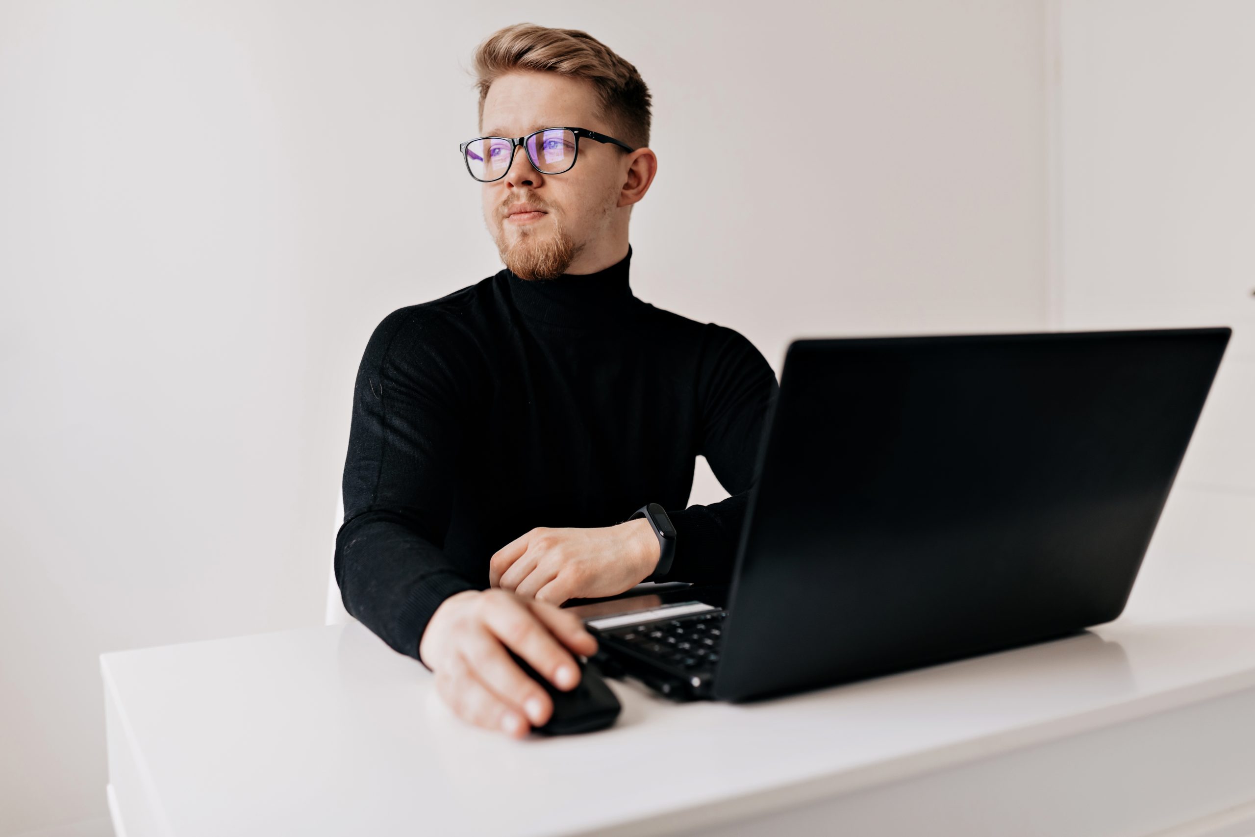 indoor-portrait-handsome-blond-man-working-laptop-white-modern-office